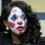 Jasmine Crockett with exaggerated clown makeup – white face paint, red nose, blue tear streaks – during a congressional hearing, symbolizing the absurdity of her Senate run and viral outrageous quotes – featured image for Glowie Rag article on Jasmine Crockett’s most clownish moments.